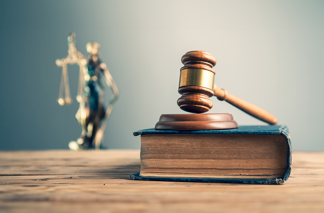 wooden judge on book with justice lady on desk