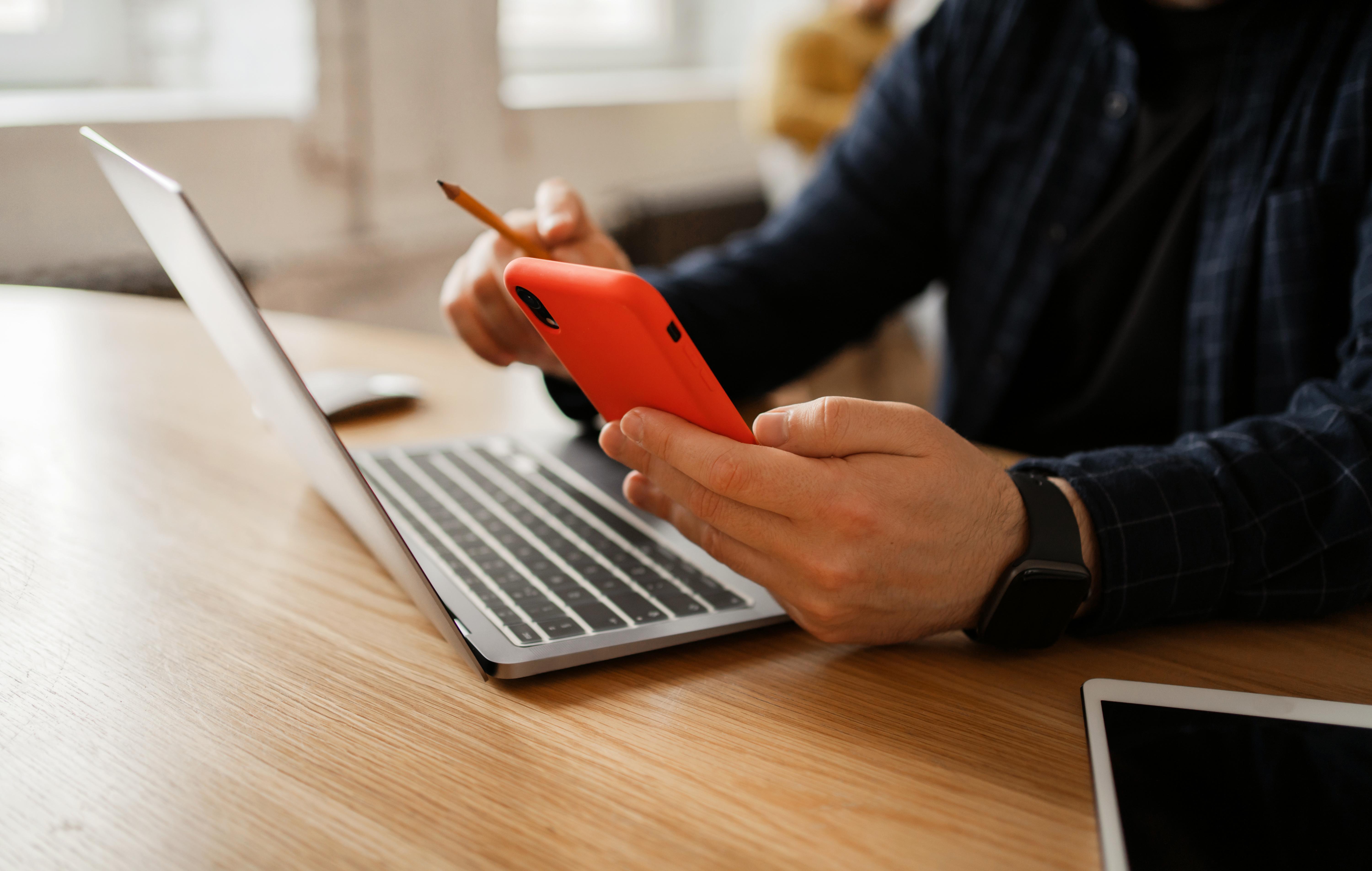 Workplace in the office with documents. A man working on the stock exchange uses a phone.  The report for the month of finance.  An open laptop with graphs and tables online.