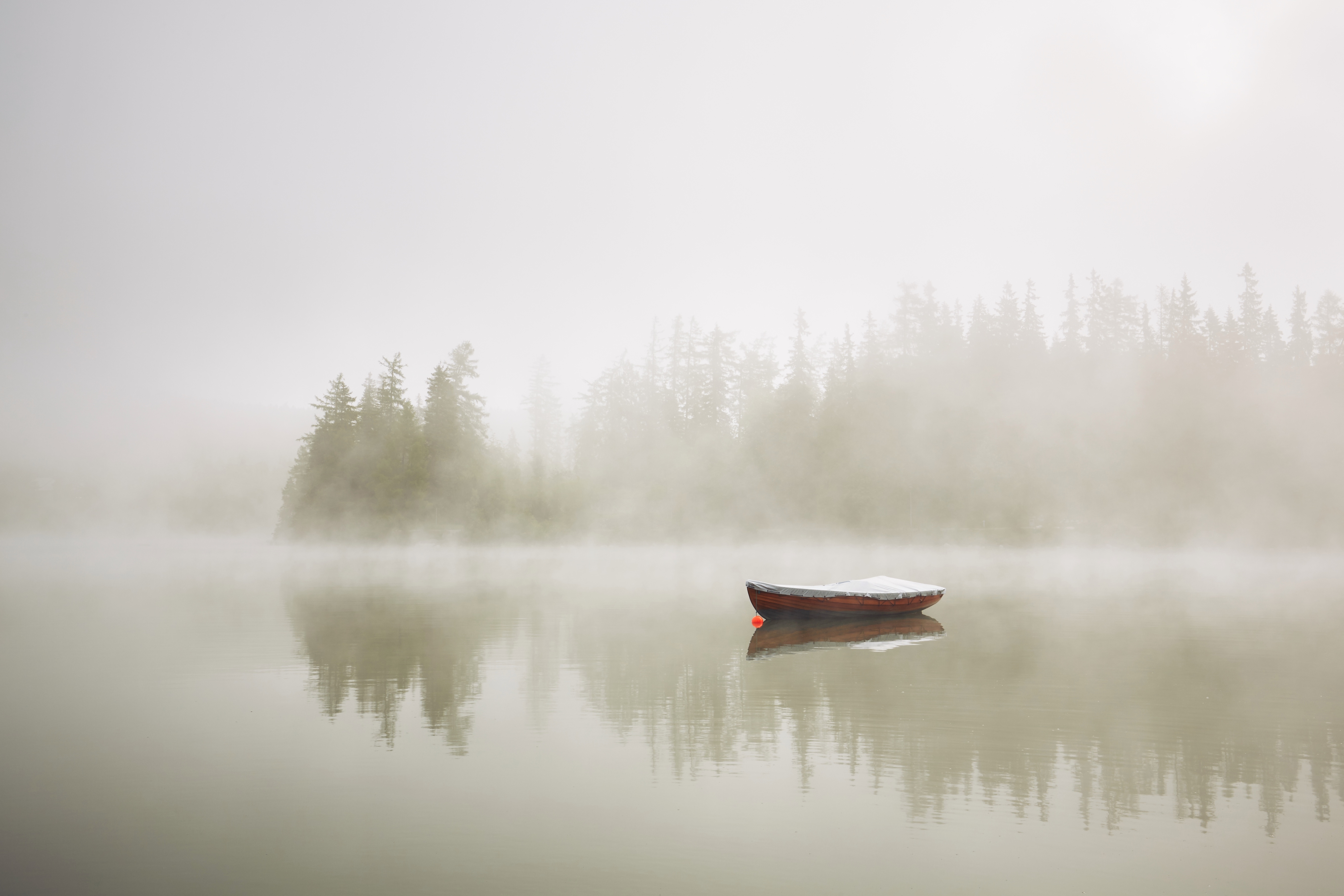 Boat on the lake at morning fog.