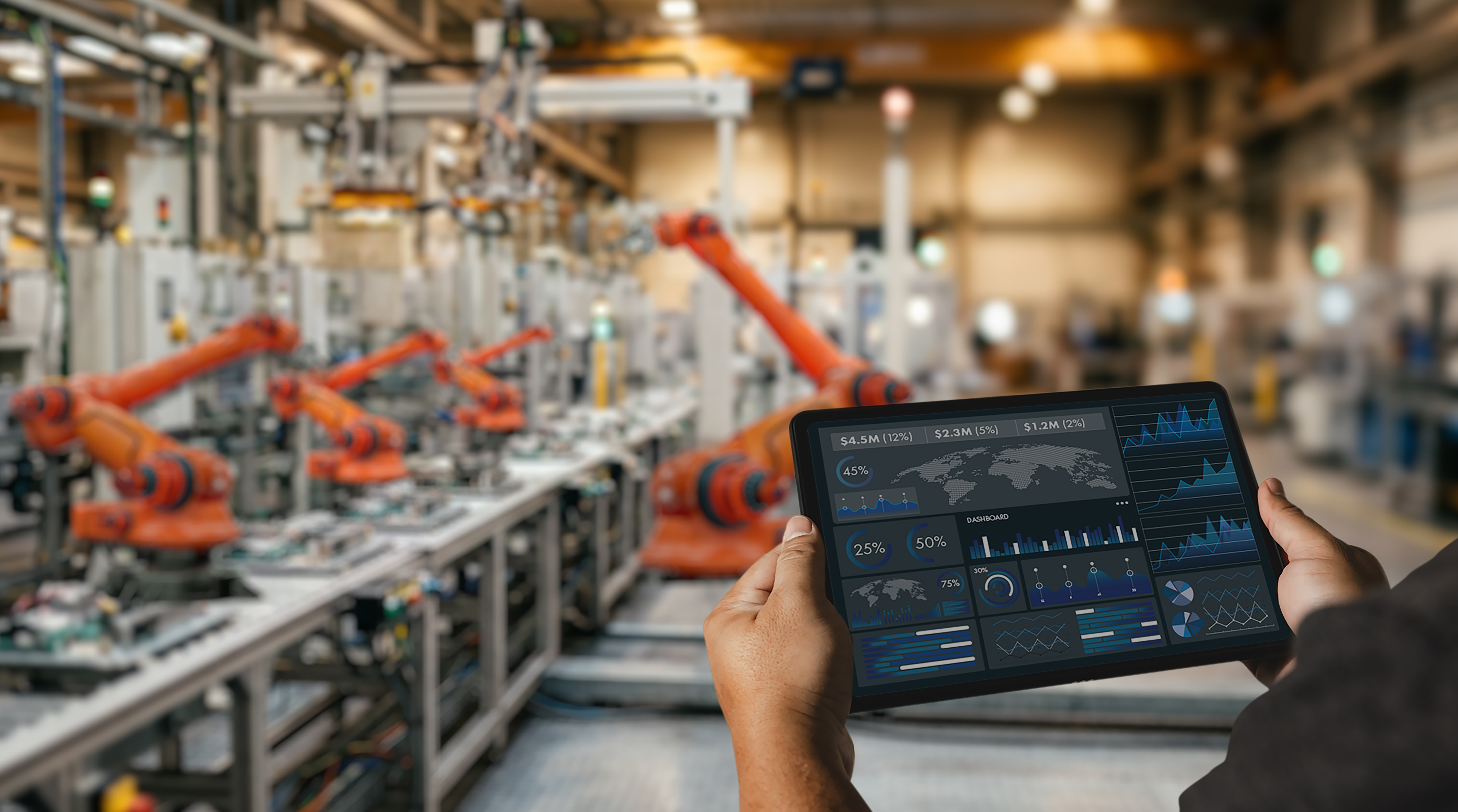 Engineer using tablet dashboard in smart factory with robotic automation system for industrial production monitoring, manufacturing analytics, and operational data management.